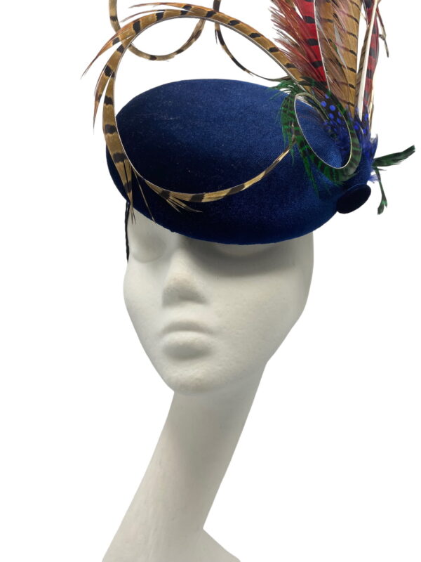 Navy blue velvet based headpiece with an array of coloured feathers.